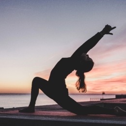 a woman stretching near water