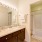 Large well lit bathroom with white accents 