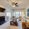 Spacious and well lit living room with wood flooring, large windows and open access to the kitchen