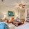 Spacious and well lit living room with wood flooring, large windows and open access to the kitchen